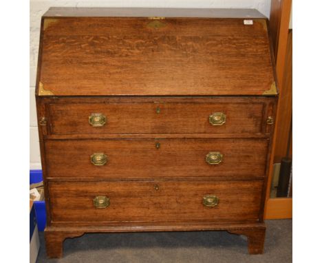 George III oak bureau, fall front enclosing interior fitted with a cupboard, drawers and pigeon holes, above three long gradu