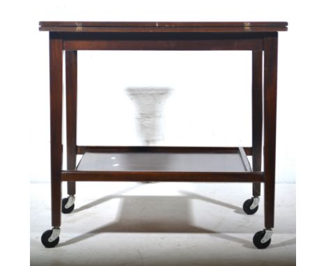 Mahogany fold over card table, with undertier shelf, raised on casters.