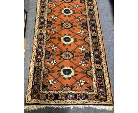 A Caucasian carpet runner, twelve foliate medallions on a red field, narrow borders,345cm x 93cm