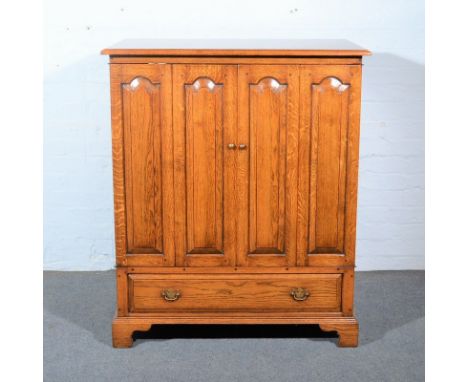 Oak television cabinet, by Haselbech Oak, two bi-fold doors, with arched fielded panels, single drawer under, on bracket feet