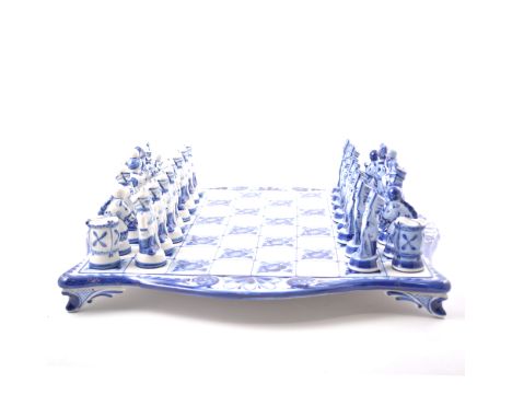 A Russian blue and white ceramic chess board and pieces by Gzhel, the board 45cm square, the pieces modelled as soldiers.