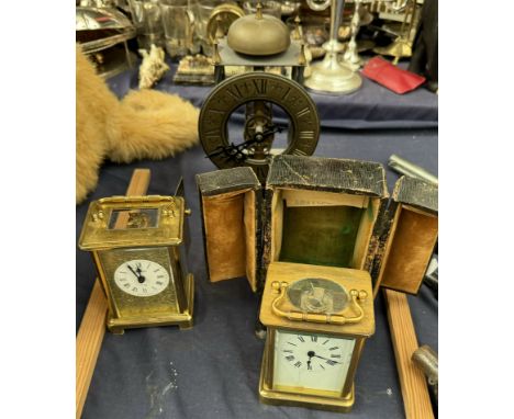 A brass cased carriage timepiece, cased together with another carriage clock and another clock