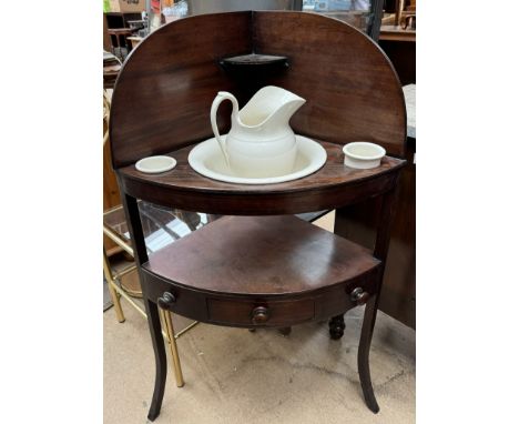 A 19th century mahogany corner washstand, with a raised back, shelf with jug, basin and pots above a shelf with drawer on squ