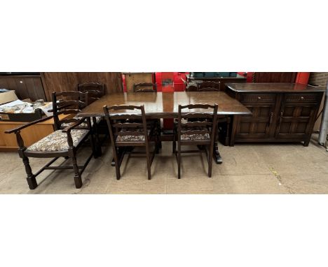 A dark oak Ercol dining table together with six ladder back chairs and a sideboard 