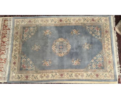A Chinese rug with a light blue ground decorated with a central roundel and flowers with guard stripes, 280 x 180cm