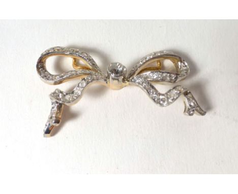 A yellow gold and platinum highlighted brooch of bow shape form set diamonds in a millegrain setting. 4. 4.4 cm, estimated to