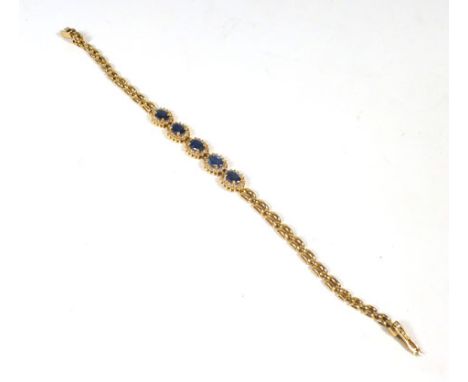 An 18ct yellow gold bracelet set five clusters, each set an oval sapphire in a surround of small diamonds. 10.9 gms