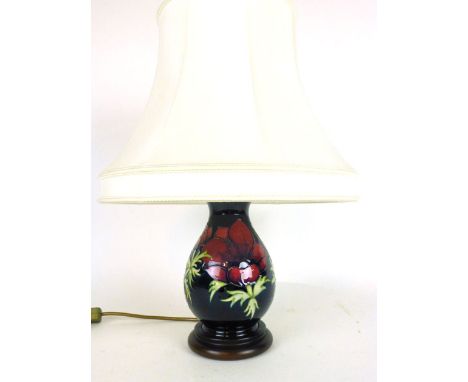 A Moorcroft vase lamp of bulbous form in an Anemone pattern on a dark blue ground, on a wooden base h. 48cm (including shade)