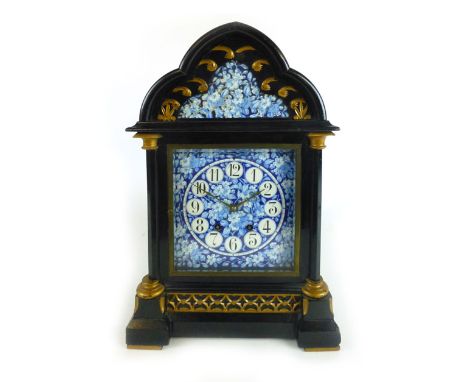 A late 19th century ebonised and parcel gilt Gothic mantle clock with blue and white floral enamel face with Arabic numerals 