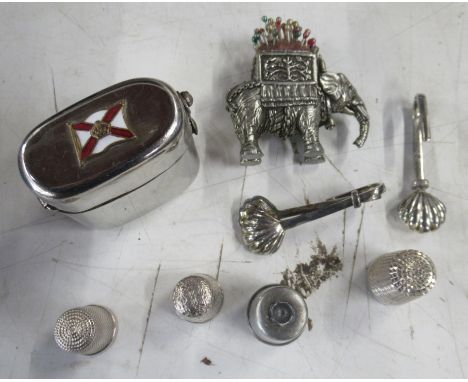 A travelling inkwell, in silver plated case, together with thimbles, an elephant pin cushion etc