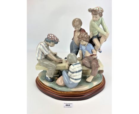 Nao group figure of boys playing cards on wooden stand, 14” wide x 14”high