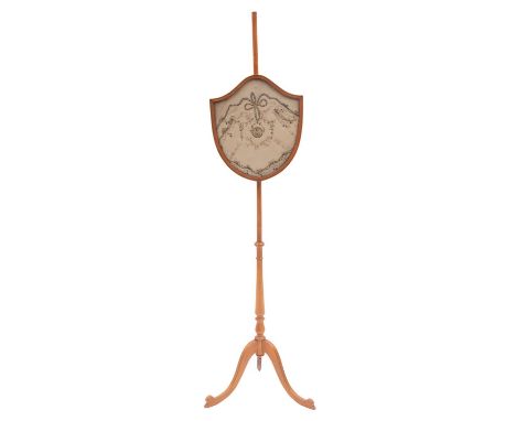 A satin birchwood firescreen, 19th Century; the crest-shaped panel with embroidered and sequined silkwork with a central meda