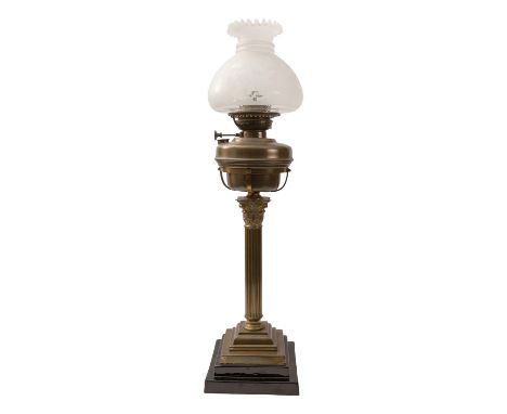 A Victorian brass table oil lamp, late 19th century; the domed and foliate etched glass shade with crimped vent, above a VERI