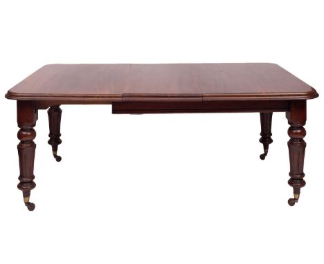 A Victorian mahogany extending dining table, circa 1880; the ovolo and ogee moulded top with rounded corners above knop turne