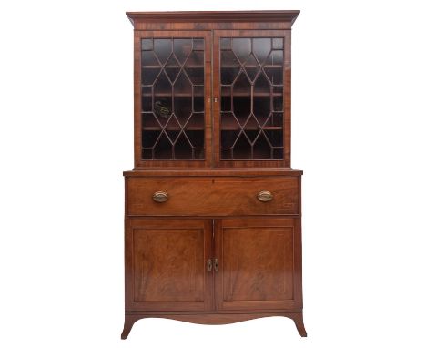 A George III mahogany and glazed secretaire bookcase, circa 1775; the moulded cornice above two glazed doors with geometric a