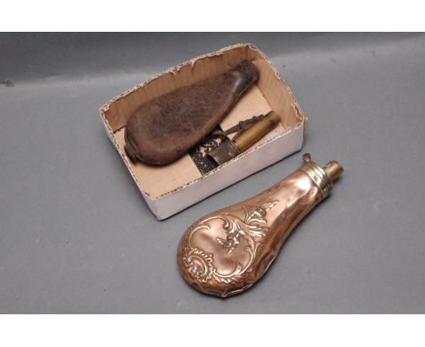 Copper and brass powder flask with floral motif, length 18 cm, and leather and brass shot flask.