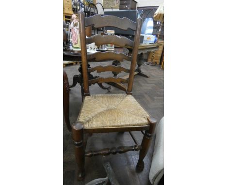 A set of four oak ladder back dining chairs with rush seats
