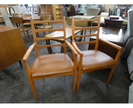 A pair of modern teak finished ladder back carver chairs with upholstered seats 