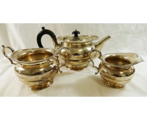 A George V silver three piece teaset, London 1918, by the Goldsmiths and Silversmiths Co., the teapot with ebonised handle an