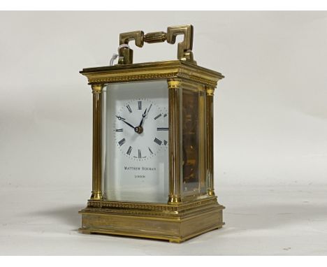 A Matthew Norman gilt brass carriage clock, with swing handle above bevelled view glass over case with fluted pilasters, encl