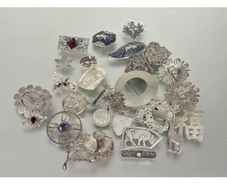 A collection of silver and white metal to include a poppy brooch, Thai black enamel dancer brooch and leaf shaped brooch, a c