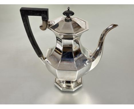 A Walker &amp; Hall Sheffield silver octagonal paneled coffee pot the hinged top with ebony knop and handle to side raised on