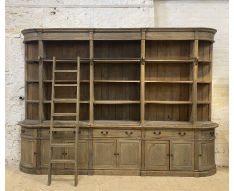 Oka, a large stained pine sectional library bookcase, fitted with a combination of adjustable shelves, cupboards and drawers,