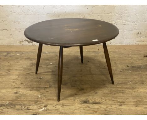 Ercol, a Vintage stained elm coffee table, circular top raised on four turned and tapered supports. H45cm, W75cm.&nbsp;