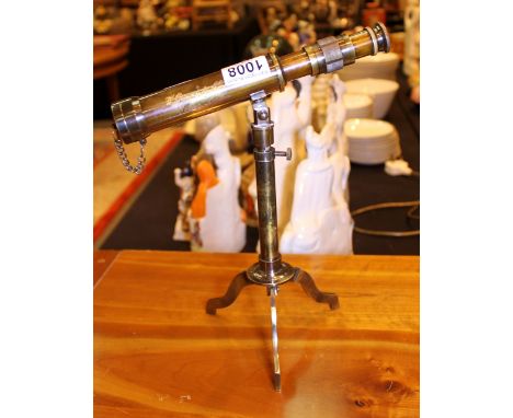 Brass miniature telescope on a tripod stand.