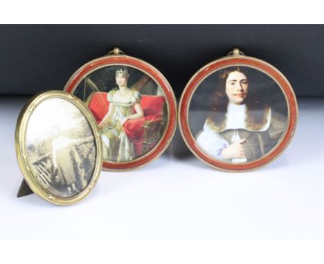 A pair of antique brass and enamel round frames together with another brass frame. 