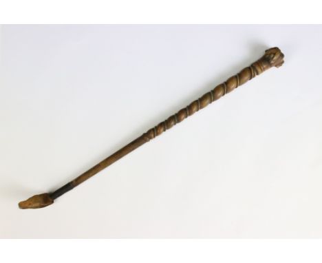 A finely carved wooden riding crop with dog's head finial, measures approx 37cm in length. 