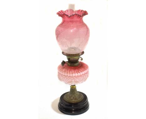 Victorian cranberry oil lamp with shaped font with etched cranberry shade and crimped edge with butterfly detail, raised on a