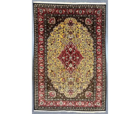 A Persian Ghom Province 100% silk floor carpet rug. The carpet having a central yellow &amp; red floral medallion with intric