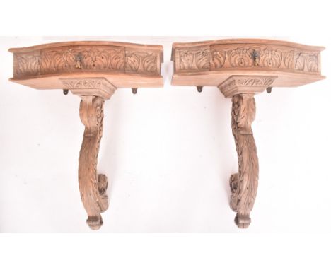 A pair of continental Rococo inspired carved stripped wood wall console hall tables. Each monopedic table having a serpentine