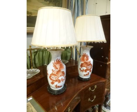 A pair of ceramic table lamps in 19th century Chinese style, 20th century, each of baluster form decorated with a Chinese dra