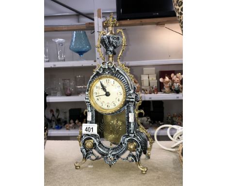 A modern decorative mantel clock in painted stone effect with brass trim