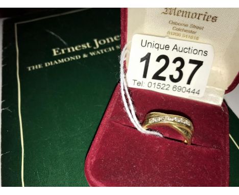 An 18ct gold crossover ring set 7 diamonds, size O. (with original receipt and guarantee).