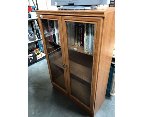 A glazed front bookcase with internal light