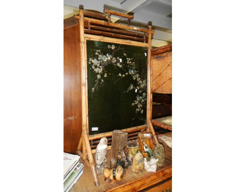 A bamboo firescreen inset with bird decorated glass panel.