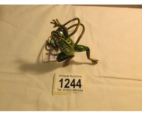 A decorative bangle with frog set green stones.