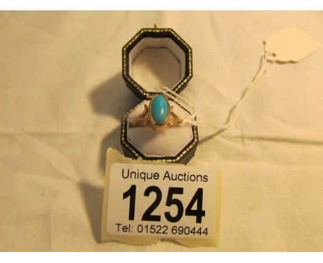 A turquoise gabachon gold ring, size M.
