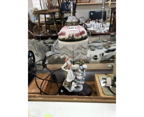 A figural lamp with painted dragonflies on shade