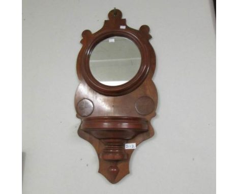 A small mahogany wall mirror with shelf.