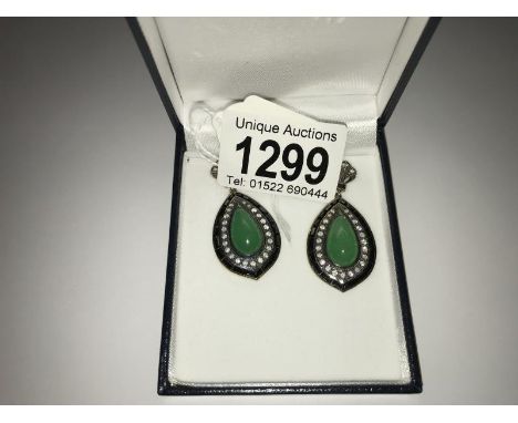 A pair of gold and silver drop earrings wet with jade, onyx and diamonds.