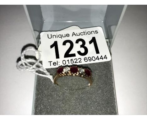 An unmarked yellow metal ring set red and white stones, size O.