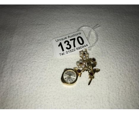 A Rotary gold ladies fob watch suspended from a pearl and garnet brooch in gold, total weight 10.3 grams, in working order.