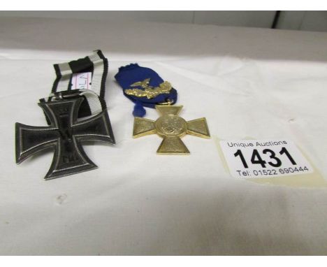 A German 25 year long service cross + oak leaves and an Iron cross first class 1914 version. (No document of authenticity).
