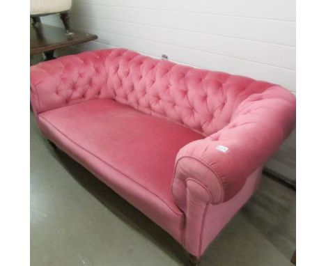 A pink Chesterfield sofa.