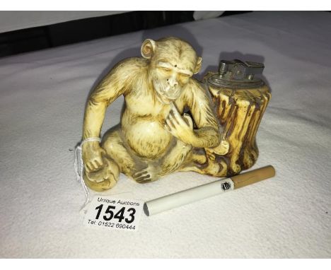 A faux ivory monkey table cigarette lighter.