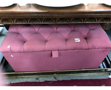 A pink button upholstered blanket box